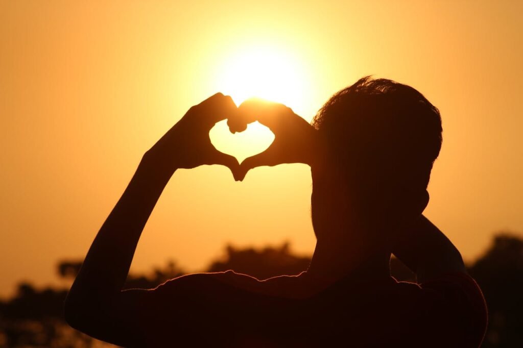 Na imagem, pessoa fazendo coração com as mãos, representando a saúde cardiovascular.